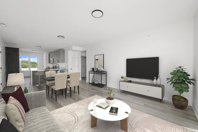 Modern open-concept living room with dining area, TV on media stand, comfortable seating, and kitchen visible in background